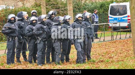 Braunschweig, Germany, December 05., 2020: Black-uniformed German police officers with helmets, visors and batons stand in a row one behind the other Stock Photo