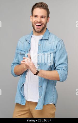 Portrait of young handsome caucasian man in jeans shirt over light background Stock Photo