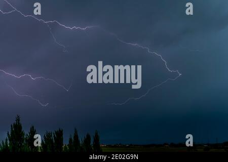 A strong storm over the countryside with lightning and thunder at the first light of the new day Stock Photo