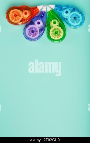 Stationery correction tapes are Multicolored on a blue background. Free space. The view from the top. Blue, green, yellow, lilac Stock Photo