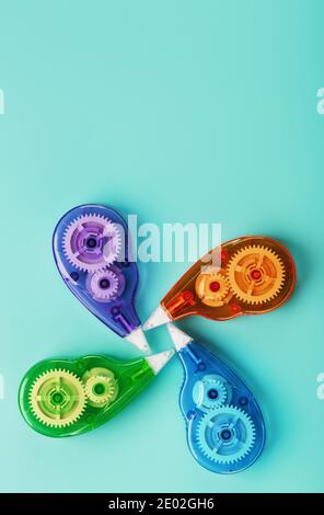 Stationery correction tapes are Multicolored on a blue background. Free space. The view from the top. Blue, green, yellow, lilac Stock Photo