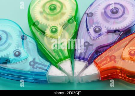 Stationery correction tapes are Multicolored on a blue background. Free space. The view from the top. Blue, green, yellow, lilac Stock Photo