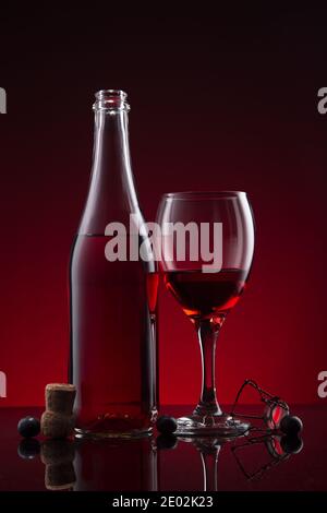 Bottle and glass of Lambrusco wine  on red dark background. Stock Photo
