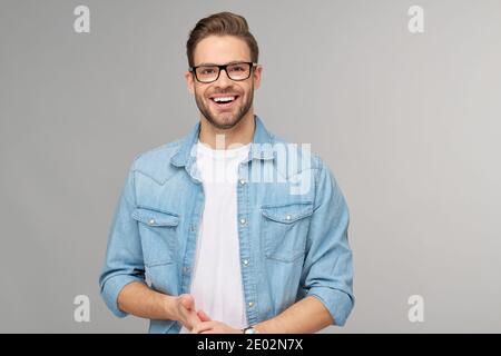 Portrait of young handsome caucasian man in jeans shirt over light background Stock Photo