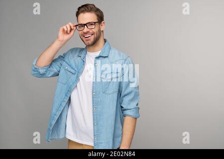 Portrait of young handsome caucasian man in jeans shirt over light background Stock Photo