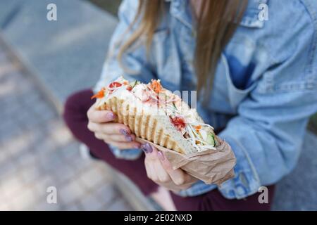 girl eats shawarma on the street. Fast food Stock Photo