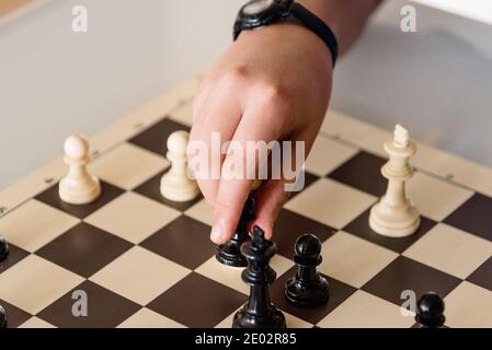 Hand of young player moving chess figure in competition. Success, strategy, leadership concept Stock Photo