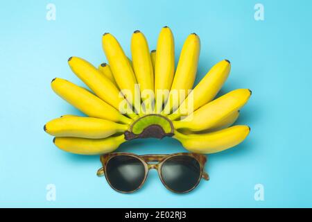 Bananas and sunglasses on a blue background. Summer, vacation, travel and sun concept. Minimal art composition Stock Photo