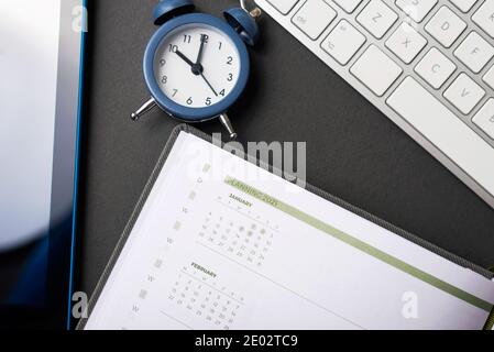 Time to planning 2021 year, photo of work desk with clock agenda and keyboard. Stock Photo