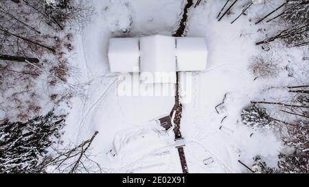 Aerial view of rural house covered with snow. Winter icy landscape, fresh stream,trees from above.Winter background of snow and frost.Picturesque Stock Photo