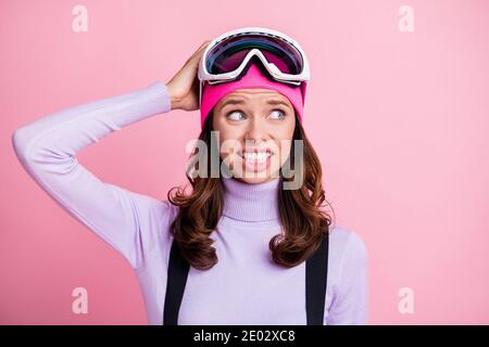 Photo portrait of confused girl scratching head isolated on pastel pink colored background Stock Photo