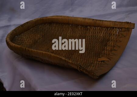 Old handmade wicker dustpan isolated. Handmade storage basket Stock Photo