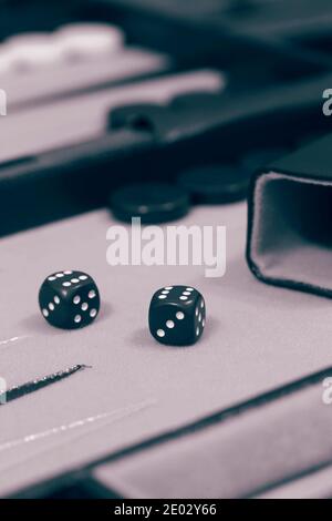 Backgammon set,  ready to start game,  on a cloth and leather board.  With colour toning Stock Photo