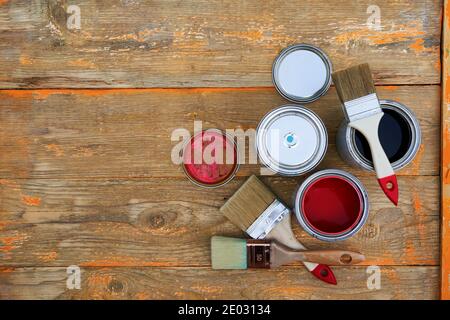 Paint cans and brushes on the old wooden background. Concept of house renovation Stock Photo