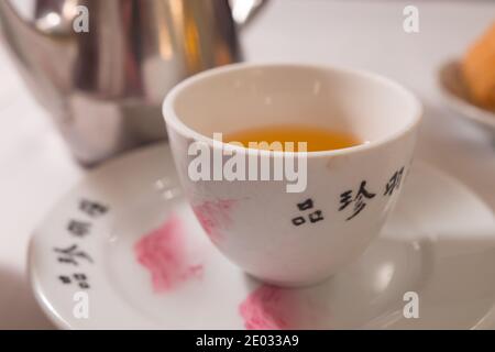 Tea service on a white table : Iron kettle, tea cup with hot tea, a soup  bowl & special spoon. Beautiful typical chinese restaurant Stock Photo -  Alamy