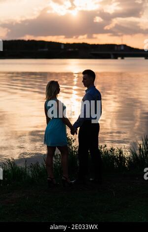 Silouette, loving couple on the lake during sunset Stock Photo