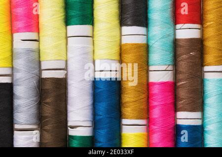 Background from multi-colored spools of thread, close-up Stock Photo