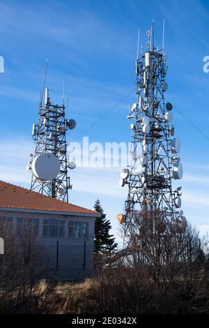 Communication tower with antennas satellite dish on blue sky background, Telecommunication tower. Stock Photo