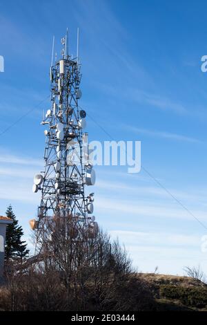 Communication tower with antennas satellite dish on blue sky background, Telecommunication tower. Stock Photo