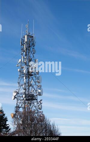 Communication tower with antennas satellite dish on blue sky background, Telecommunication tower. Stock Photo