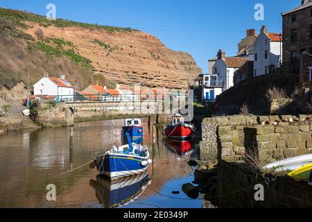 Staithes harbour, a once important fishing port, also known for its unique and colourful 'cobles' fishing boats that still fish lobster and mackeral. Stock Photo