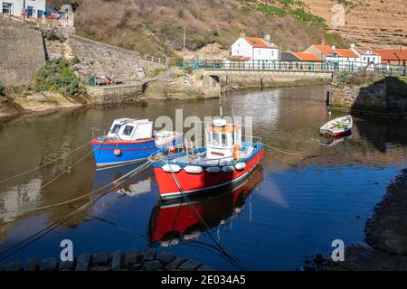 Staithes harbour, a once important fishing port, also known for its unique and colourful 'cobles' fishing boats that still fish lobster and mackeral. Stock Photo