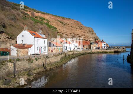 Staithes harbour, a once important fishing port, also known for its unique and colourful 'cobles' fishing boats that still fish lobster and mackeral. Stock Photo