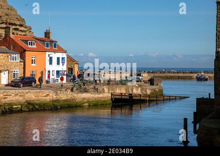 Staithes harbour, a once important fishing port, also known for its unique and colourful 'cobles' fishing boats that still fish lobster and mackeral. Stock Photo