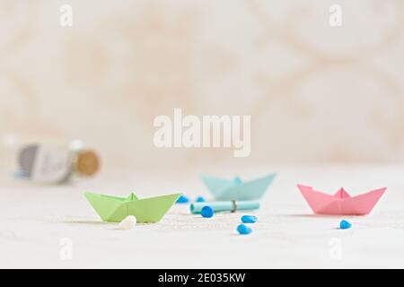 Colorful paper boats on blurred background, paper art, children's handicrafts Stock Photo