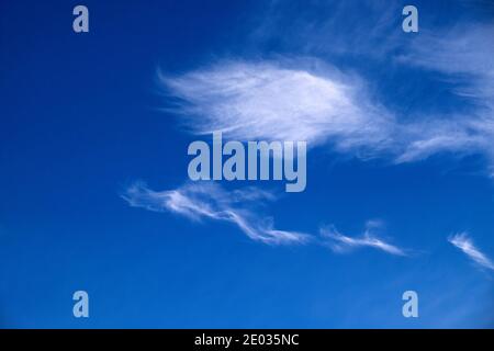 Wispy white cirrus clouds in blue sky background with copy space floating above Wales Great Britain  KATHY DEWITT Stock Photo