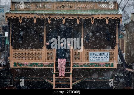 Srinagar, India. 29th Dec, 2020. An Indian tourist enjoys fresh snowfall in Srinagar. Fresh snowfall was recorded in parts of Kashmir valley including the summer capital, Srinagar leading to the closure of the Srinagar-Jammu National Highway, officials said. Credit: SOPA Images Limited/Alamy Live News Stock Photo