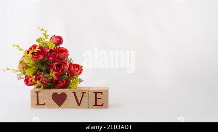 Love wooden cubes and red bouquet decoration isolated on white background, copy space Stock Photo