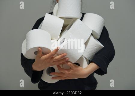Asian woman carrying multiple rolls of toilet paper, paper crisis concept, storing toilet paper Stock Photo