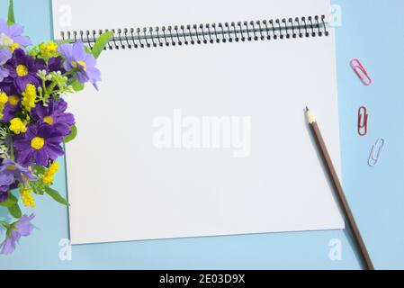 Blank notebook mockup. Template for advertising or branding. Notebook, pen, flowers, paper clips in office workspace Stock Photo