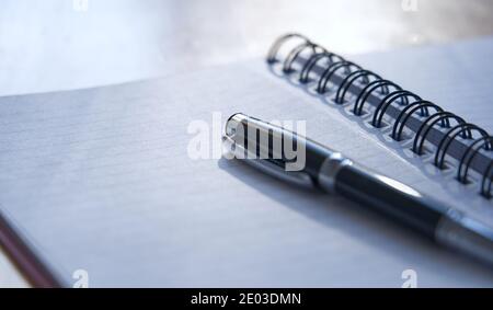 Closeup of black pen and spiral-bound notebook, copy text space Stock Photo