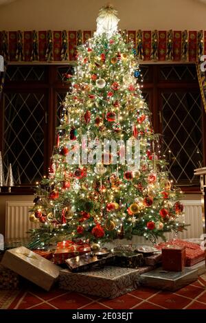 Traditional UK Home Christmas Tree with presents under Stock Photo