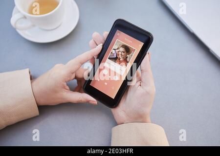 Close-up of woman loading her photo on mobile phone and using dating app online Stock Photo
