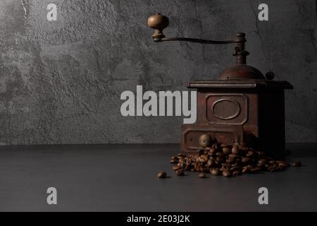 Old coffee grinder and coffee beans. Gray background with an aromatic cafe theme. Stock Photo