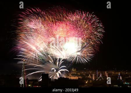 Fireworks. Colorful huge fireworks explode in dark sky background and house light in the far in Zurrieq, Malta Malta fireworks festival, 4 of July, In Stock Photo