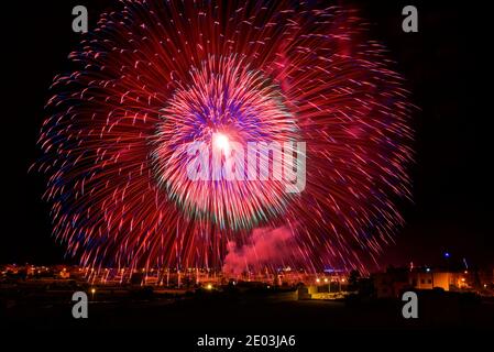 Big fireworks explosion in the village Zurrieq during local religion feast Santa Katarina, Malta. Amazing fireworks. Happy New Year. Saturated Stock Photo