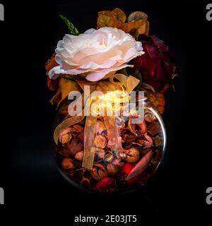 Bouquet of autumn orange and white flowers in a glass vase isolated against a black background. Stock Photo