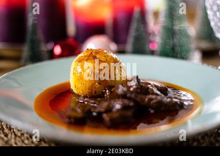 Delicious christmas dinner with dumpling and christmas decoration in the background Stock Photo