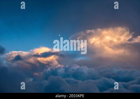 A gibbous moon above dramatic cumulus clouds, seen from high in the Dolomites, northern Italy Stock Photo