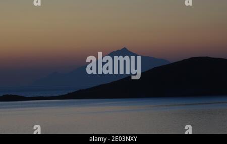 Sunset on Plati Beach , Myrina, Lemnos Island in the Greek Islands with views of Ormos Vatopediou ,  Athos Mountain in the background Stock Photo