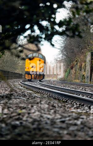 English Electric Type 3 British Rail Class 37 diesel locomotive number 37716 running on railway tracks by the river Tyne near Hexham Northumberland Stock Photo