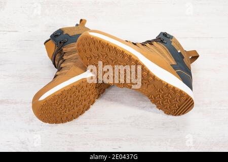 A pair of men's sports winter brown and blue shoes on a white wooden background. Stock Photo