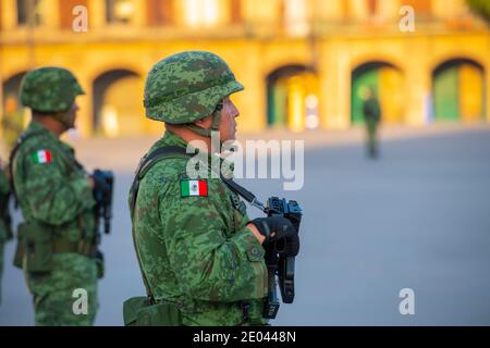 Raising Flag Guard of Honor standing on Zocalo at Historic center of Mexico City CDMX, Mexico. Historic center of Mexico City is a UNESCO World Herita Stock Photo