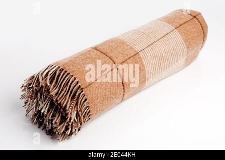 Warm brown alpaca wool or cashmere blanket isolated on white background. Beige, brown squared wool fabric for house design. Stock Photo