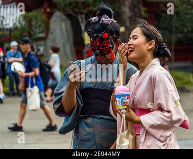 Bizarre situation: kimono wearing masked couple. Street Life in Tokyo, Japan