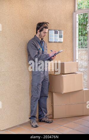 Messenger with mask delivers packages to the doorway next to the doorkeeper